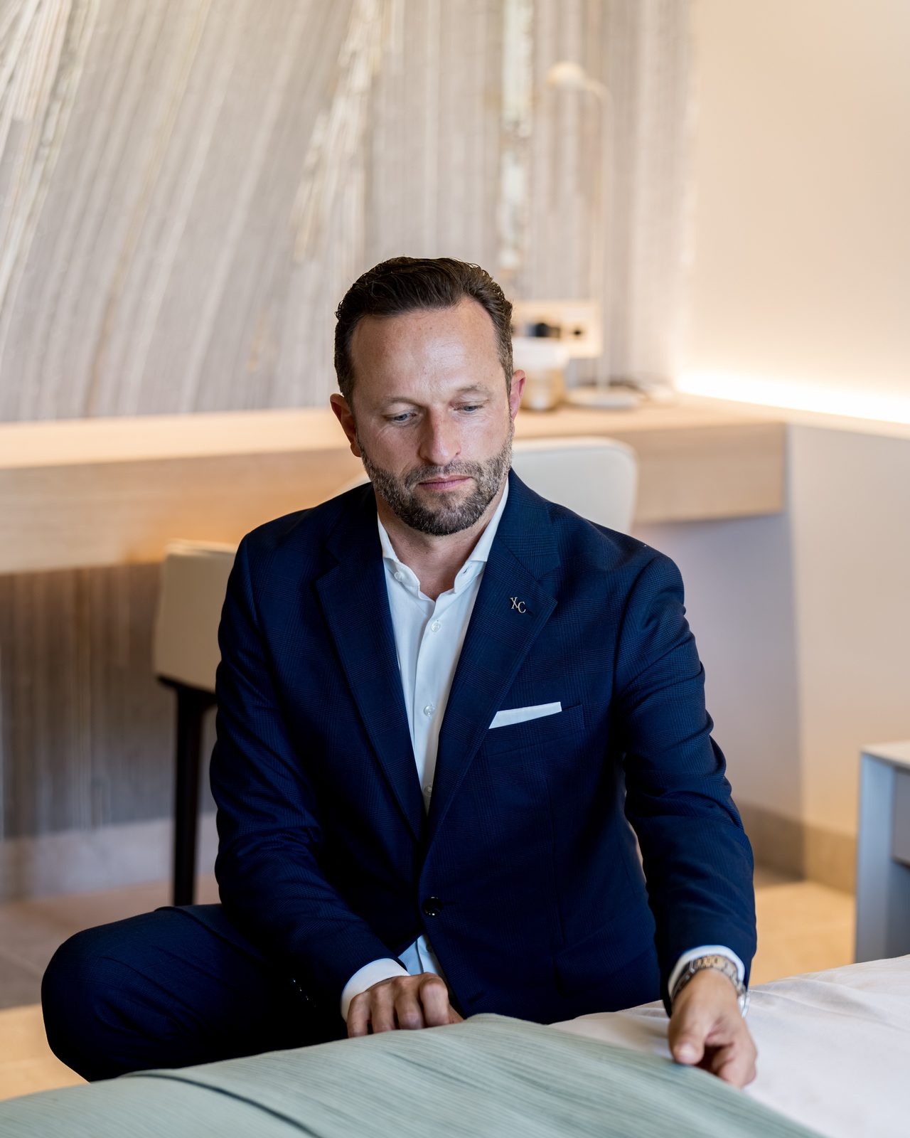 Daniel Rudolf — Editorial-Portrait, sitzend in einer Luxussuite.